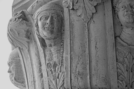Venice, Italy, Sept. 17, 2023: Atop a pillar in the Doges Palace portico, three medieval carved heads of men stare out, each face with an intriguing expression.  