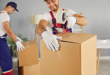 Commercial moving service workers pack stuff and prepare boxes to transport to new house or...