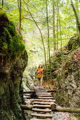 Adventure, travel, tourism, hike and people concept. Smiling woman walking with backpacks in woods.