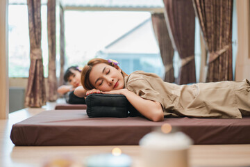 Woman and friend enjoying a professional massage at in spa salon. Relaxing Spa Massage Therapy Concept.