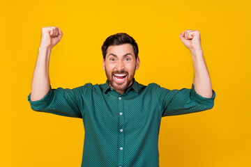 Naklejka premium Photo of crazy funny guy dressed dotted shirt raising fists up supporting football team win bet isolated on yellow color background