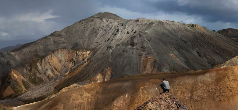View of a person taking photos on the ridge of a volcano in the highlands of Iceland.