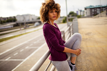 Young woman stretching before exercising and jogging in a parking lot