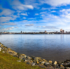 Majestic clouds hover over waterfront condos in Edgewater, NJ, with a picturesque view of Upper Manhattan.