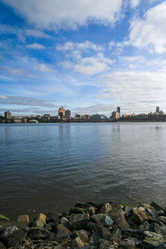 Majestic clouds hover over waterfront condos in Edgewater, NJ, with a picturesque view of Upper Manhattan.