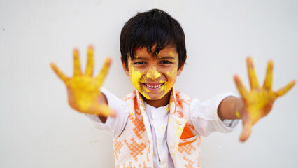 Happy Cute Smiling looking kids playing with paints in their fingers. Holi Festival of colors