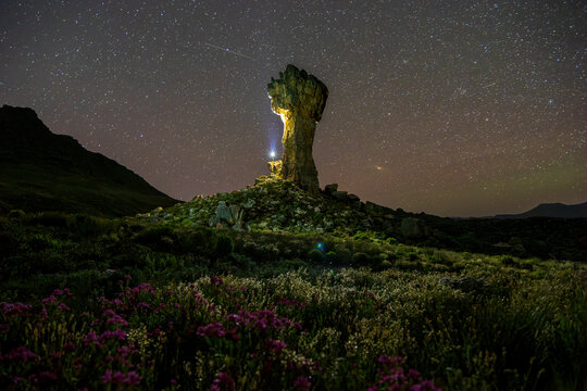 View of Maltese Cross at night and hiker, Cederberg, Western Cape, South Africa