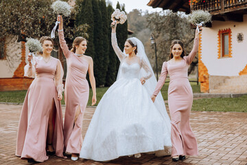 Wedding photography. A brunette bride in a white dress with a bouquet and her brunette girlfriends