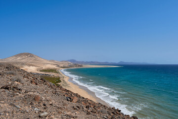 The Atlantic Ocean and Sotavento beach with clear sky and mountains in back