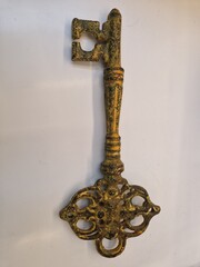 Old key isolated on white. Ornate, gold master key on white with clipping path. Antique key...