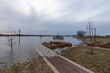 flooded park with paths and sidewalks, early spring flood, river overflowing its banks,...