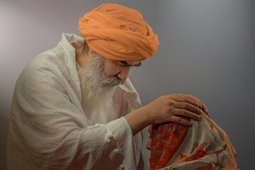 Senior man in a turban is associated with a Hindu, Jain, Buddhist blessing of healing by laying on...