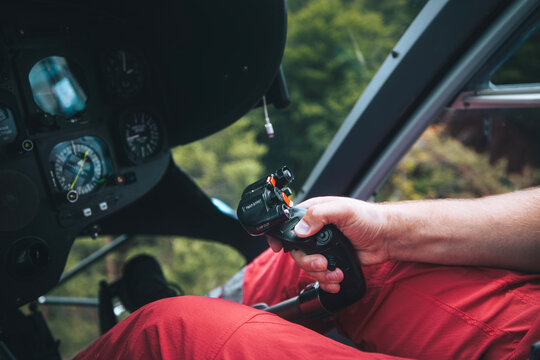 Pilot Helicopter Emergency Medical Service during flight above forest. Close-up of flight control inside cockpit..