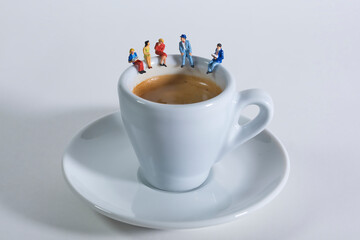 Photography of miniature people and toy figures, a group of people sits on a coffee cup for a break