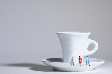 Photography of miniature people and toy figures, a group of people sits on a coffee cup for a break