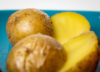 A close-up view of two halved young golden potatoes, roasted to perfection, displayed on a plate.