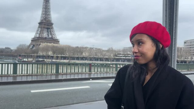 Paris streets walking, Eiffel tower background. Cinematic footage portrait of a young beautiful happy woman in red French beret. European tourism and travels to the capital cities