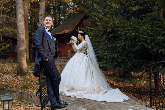 Wedding couple on a walk in the autumn park. The bride in a beautiful white dress. Love and relationship concept. Groom and bride in nature outdoors