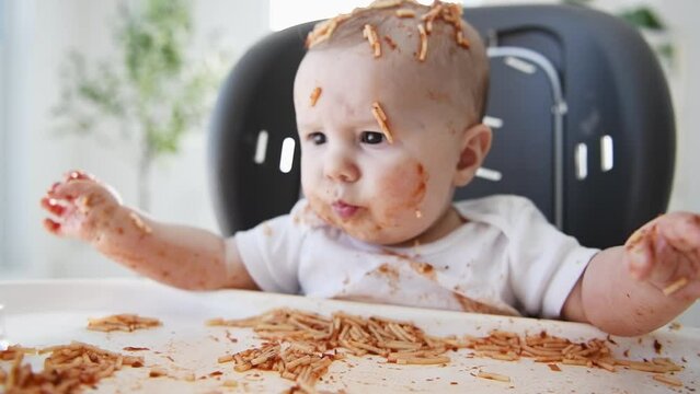 Little baby eating her dinner and making a mess