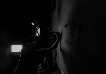 a man is hammering nails into a wall on a black and white background