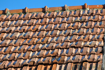 On the roof of the house is an old red tile