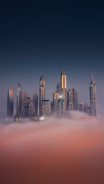 Aerial view of Dubai Marina at twilight with Cayan Tower, fog and skyscrapers, Dubai, United Arab Emirates.
