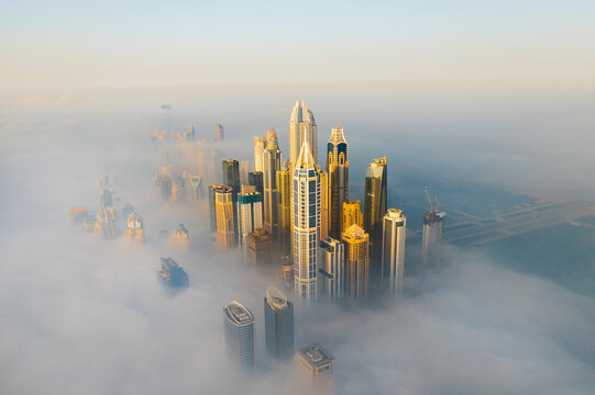 Aerial view of Dubai Marina at sunrise with fog and skyscrapers, Dubai, United Arab Emirates.