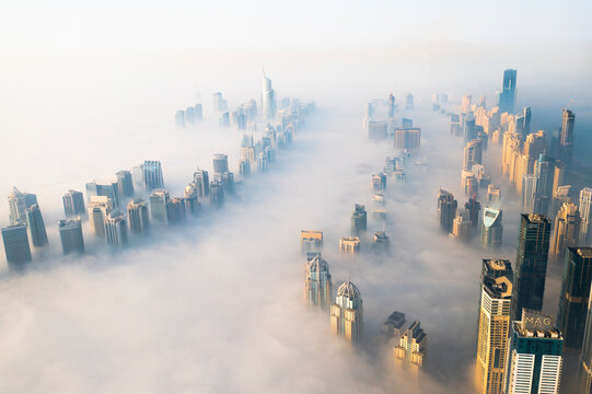 Aerial view of Dubai Marina with skyscrapers surrounded with fog, Dubai, United Arab Emirates.