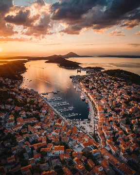Aerial view of coastal town with orange sunset and marina, Mali Losinj, Primorje-Gorski Kotar, Croatia.