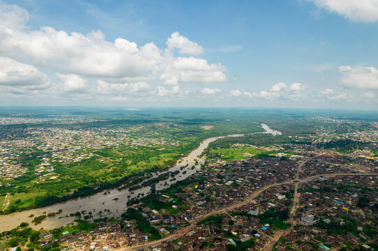 Aerial view of a green, expansive landscape with rooftops and roads, Ogun State, Nigeria.