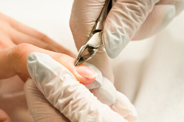 Woman in a nail salon receiving a manicure by a beautician with nail file. Beauty and hand care...