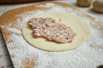 A piece of dough with minced meat for cheburek