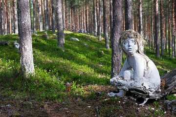 Statue of a creepy child, part of the Oranki Art project in a forest in Lapland, Finland