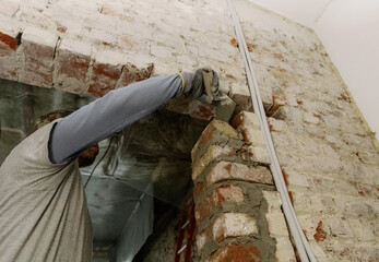 A young man places bricks in a doorway.