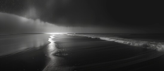 A long exposure shot of the ocean under a dramatic sky, showcasing the dynamic movement of the waves and the vast expanse of the horizon in black and white tones.