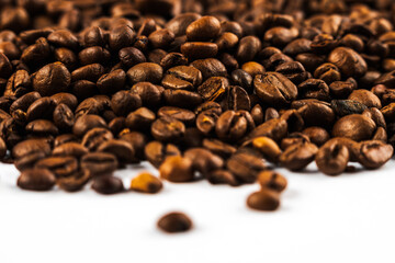 Coffee beans on a white background. A heap of coffee beans on white. Morning coffee
