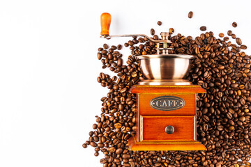 Coffee grinder on a pile of coffee beans. Coffee beans isolated on white background. Old wooden...