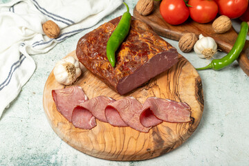 Smoked cold beef sirloin and slices on cutting board. Cold roastbeef slices on gray background