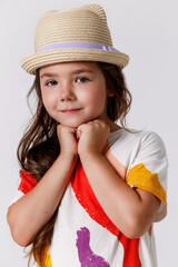 Portrait of cute kid girl in straw hat arm touch chin on white background