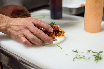 Chef Making Chicken Bao on White Cutting Board