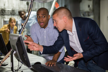 Multiracial people trying to find solution of conundrum in escape room