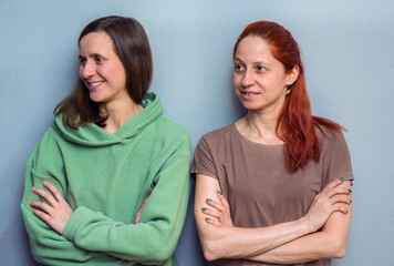 Portrait of two Caucasian women, standing together with folded arms