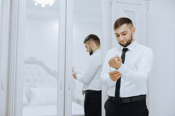 The man put on his shirt and straightens cufflinks. The groom fasten cufflinks on the cuffs of the...