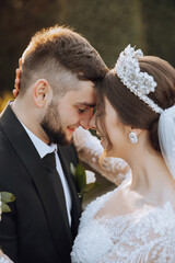 A young bride and groom tenderly embrace in the rays of the autumn sun. Tender and beautiful young...