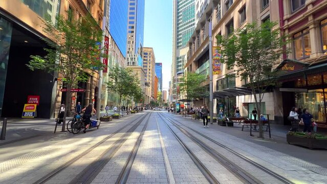 Sydney George Street in the heart of the CBD with Tram tracks central of the St and shops building and pedestrian Sydney NSW Australia