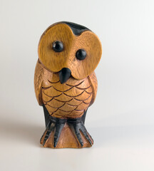 Brown wooden owl figurine carved from hardwood on a white background.