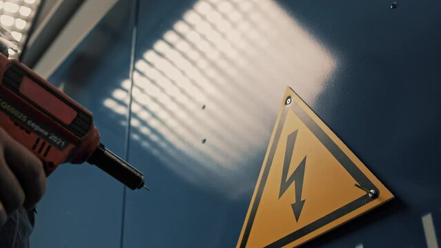 Warning sign yellow triangle with a lightning bolt on a switch cabinet with 220 volt high voltage equipment