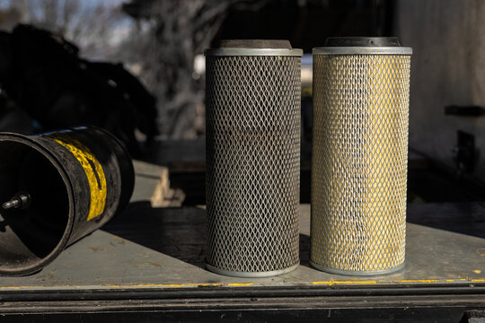 Comparison of old and new air filter of a truck or van. Metal mesh filter with paper insert, side by side dirty and clean version.