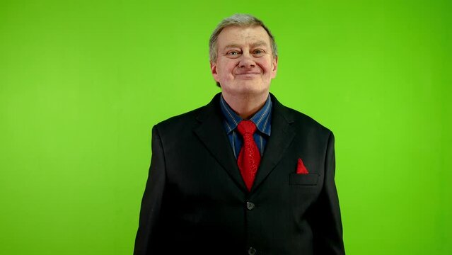 Positive senior businessman looking at camera nodding head answering yes.