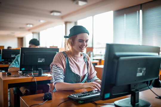 Female college student using computer at library
